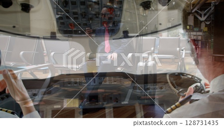 Composite image of two male pilots in the cockpit over african american businessmen using smartphone Composite image of two male pilots in the cockpit over african american businessmen using smartphone 128731435