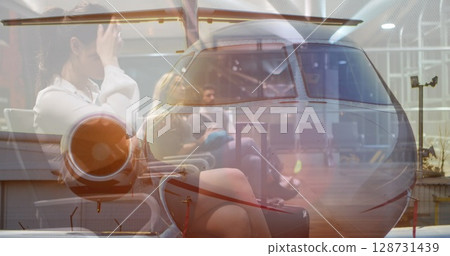 Composite image of plane against asian businesswoman using smartphone sitting at airport Composite image of plane against asian businesswoman using smartphone sitting at airport 128731439