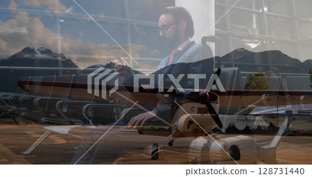 Sitting businessman in navy suit checking smartphone at airport lounge, with prop plane, copy space Sitting businessman in navy suit checking smartphone at airport lounge, with prop plane, copy space 128731440