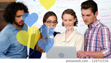 Image of yellow and blue hearts falling over diverse businesspeople working in office 128731550