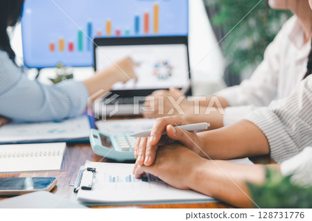 Financial business team in office, financial expert analyze business report graph and finance chart at corporate office. Concept of finance economy, banking business and stock market research. Financial business team in office, financial expert analyze business report graph and finance chart at corporate office. Concept of finance economy, banking business and stock market research. 128731776