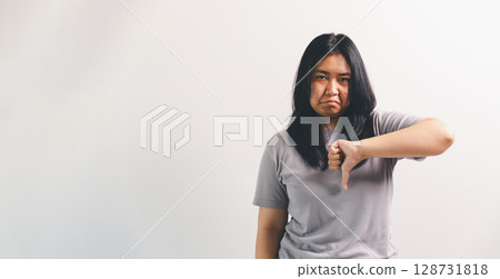 Asian girl expresses dislike, person express negative feeling, concept business complaint from customer ensuring employee satisfaction negative feedback to prevent mental strain customer dislike Asian girl expresses dislike, person express negative feeling, concept business complaint from customer ensuring employee satisfaction negative feedback to prevent mental strain customer dislike 128731818