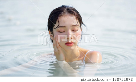 Young woman relaxing in the pool 128731978