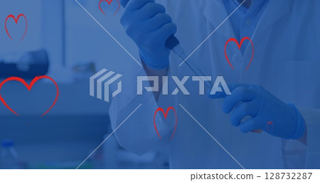 Performing gloved researcher pipetting liquid into vial at bench with heart overlay, copy space 128732287
