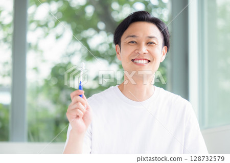 Oral care: A man holding a toothbrush 128732579