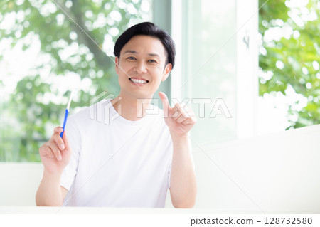 Oral care: A man holding a toothbrush Oral care: A man holding a toothbrush 128732580
