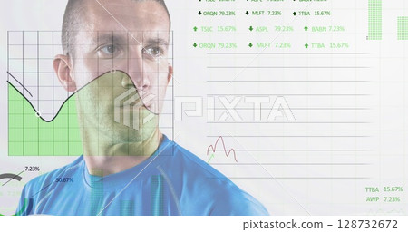 Standing adult man wearing blue top in studio, viewing green shaded chart and line graphs 128732672