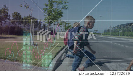 Running school-age boys carrying backpacks and crossing park edge road, with crosswalk stripes 128732689