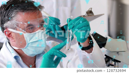 Examining scientist wearing lab coat, goggles, teal gloves analyzing test tube at lab, copy space 128732694