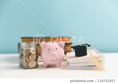 Concept of saving money for education, student loan, scholarship in future. Piggy bank with graduation hat, stack of coins. Earth globe with graduation hat, dollar banknotes on table. Tuition fees 128732857