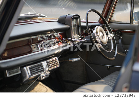 Vintage Classic car steering wheel, with chrome and leather textures in sharp detail, showcases the quality and precision of automotive craftsmanship under natural light. Vintage Classic car steering wheel, with chrome and leather textures in sharp detail, showcases the quality and precision of automotive craftsmanship under natural light. 128732942