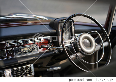 Vintage Classic car steering wheel, with chrome and leather textures in sharp detail, showcases the quality and precision of automotive craftsmanship under natural light. Vintage Classic car steering wheel, with chrome and leather textures in sharp detail, showcases the quality and precision of automotive craftsmanship under natural light. 128732946