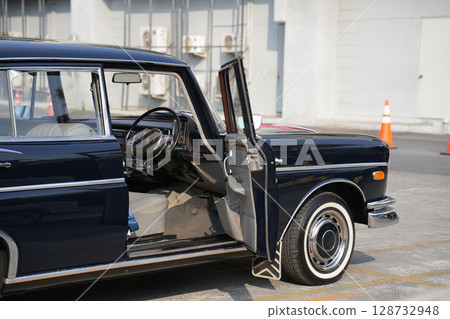 Vintage Classic car steering wheel, with chrome and leather textures in sharp detail, showcases the quality and precision of automotive craftsmanship under natural light. 128732948