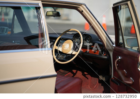 Vintage Classic car steering wheel, with chrome and leather textures in sharp detail, showcases the quality and precision of automotive craftsmanship under natural light. Vintage Classic car steering wheel, with chrome and leather textures in sharp detail, showcases the quality and precision of automotive craftsmanship under natural light. 128732950