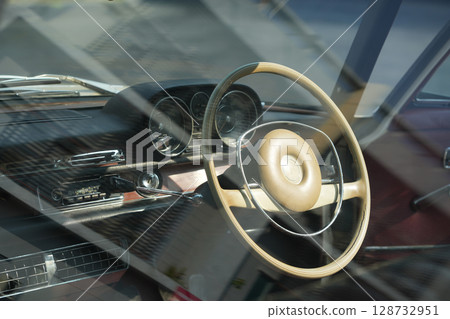 Vintage Classic car steering wheel, with chrome and leather textures in sharp detail, showcases the quality and precision of automotive craftsmanship under natural light. Vintage Classic car steering wheel, with chrome and leather textures in sharp detail, showcases the quality and precision of automotive craftsmanship under natural light. 128732951