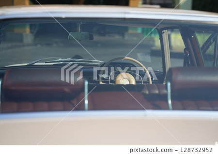 Vintage Classic car steering wheel, with chrome and leather textures in sharp detail, showcases the quality and precision of automotive craftsmanship under natural light. Vintage Classic car steering wheel, with chrome and leather textures in sharp detail, showcases the quality and precision of automotive craftsmanship under natural light. 128732952