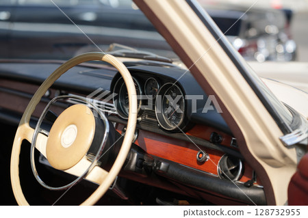 Vintage Classic car steering wheel, with chrome and leather textures in sharp detail, showcases the quality and precision of automotive craftsmanship under natural light. Vintage Classic car steering wheel, with chrome and leather textures in sharp detail, showcases the quality and precision of automotive craftsmanship under natural light. 128732955