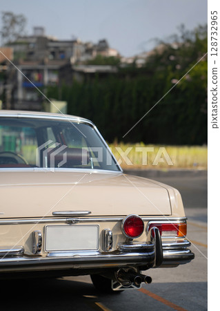 The tail lights, turn signals, and chrome accents on the rear of classic cars exude vintage charm and sophisticated design. 128732965