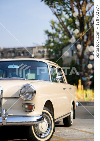The round headlights and side turn signals on classic cars, framed in polished chrome, highlight the vintage style with old-fashioned lighting and curved fender details. 128732977