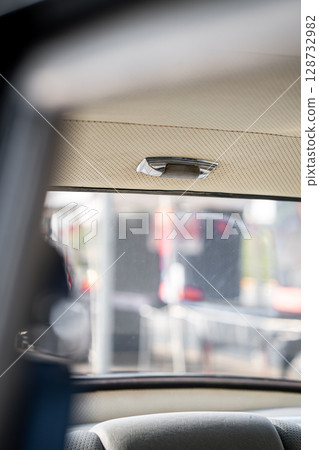 The interior dome light in a classic car, mounted on the ceiling, delivers soft, comfortable lighting, ideal for reading and creating a cozy cabin environment. 128732982