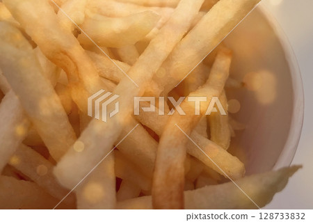 Macro shot of crispy golden French fries in warm light, perfect for food blogs, restaurant menus, ads, and snack branding. 128733832