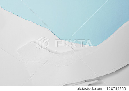 Stack of pieces of ripped and torn white paper on a blue background. Copy space Stack of pieces of ripped and torn white paper on a blue background. Copy space 128734233
