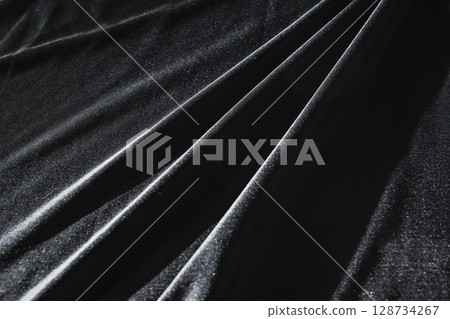 Black satin silk with crumpled abstract texture background. Material textile surface. Copy space 128734267