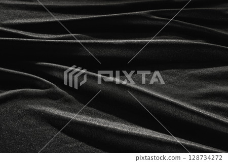 Black satin silk with crumpled abstract texture background. Material textile surface. Copy space 128734272