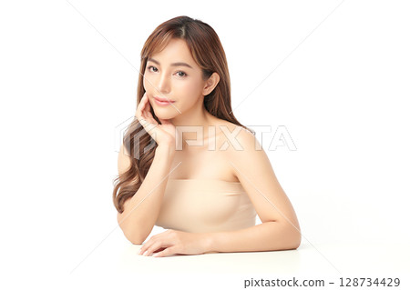 A beautiful young Asian woman with clean, fresh skin against a white background. Skincare, facial treatment, cosmetology, beauty, and spa. An elegant portrait of an Asian woman. 128734429