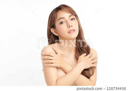 A beautiful young Asian woman with clean, fresh skin against a white background. Skincare, facial treatment, cosmetology, beauty, and spa. An elegant portrait of an Asian woman. 128734430