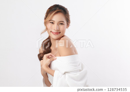 A beautiful young Asian woman with clean, fresh skin against a white background. Skincare, facial treatment, cosmetology, beauty, and spa. An elegant portrait of an Asian woman. 128734535