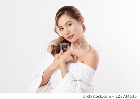 A beautiful young Asian woman with clean, fresh skin against a white background. Skincare, facial treatment, cosmetology, beauty, and spa. An elegant portrait of an Asian woman. 128734536