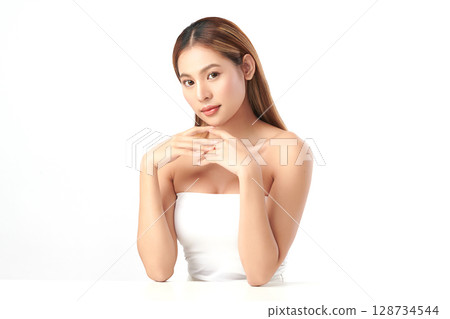 A beautiful young Asian woman with clean, fresh skin against a white background. Skincare, facial treatment, cosmetology, beauty, and spa. An elegant portrait of an Asian woman. 128734544