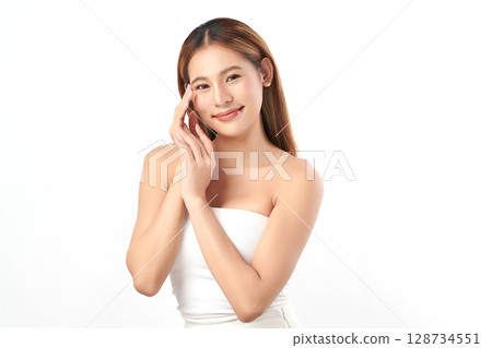 A beautiful young Asian woman with clean, fresh skin against a white background. Skincare, facial treatment, cosmetology, beauty, and spa. An elegant portrait of an Asian woman. 128734551