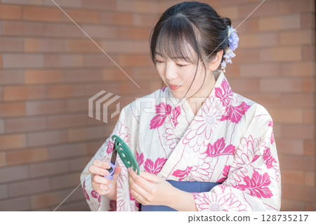 A woman in a yukata and mosquito coils 128735217
