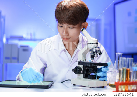 Scientist recording the results of the study in a laboratory journal. Scientist recording the results of the study in a laboratory journal. 128735541