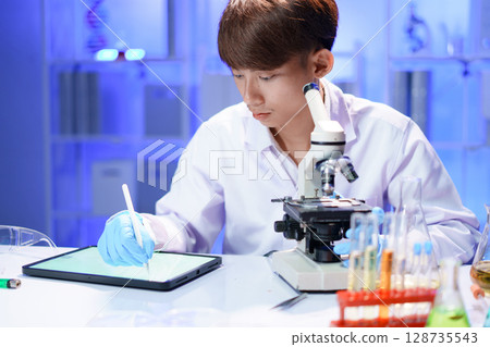 Scientist recording the results of the study in a laboratory journal. Scientist recording the results of the study in a laboratory journal. 128735543