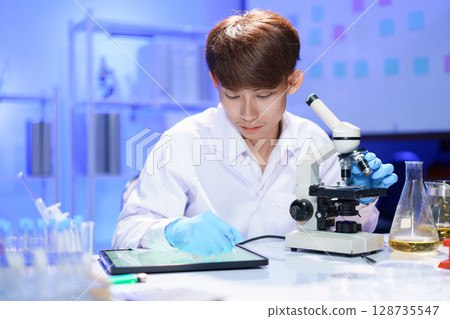Scientist recording the results of the study in a laboratory journal. Scientist recording the results of the study in a laboratory journal. 128735547