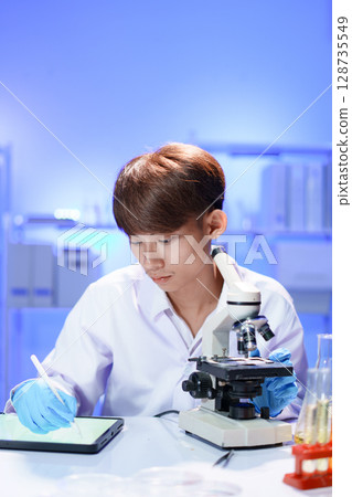 Scientist recording the results of the study in a laboratory journal. Scientist recording the results of the study in a laboratory journal. 128735549