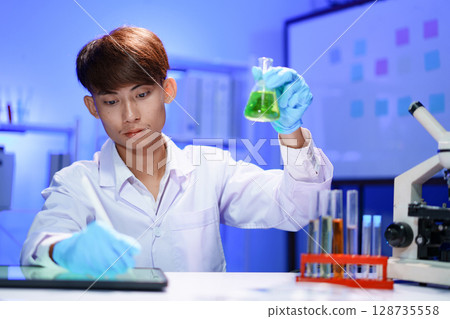 Scientist recording the results of the study in a laboratory journal. Scientist recording the results of the study in a laboratory journal. 128735558