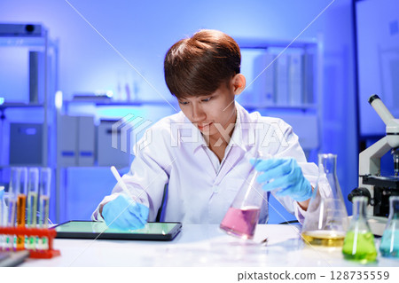 Scientist recording the results of the study in a laboratory journal. Scientist recording the results of the study in a laboratory journal. 128735559