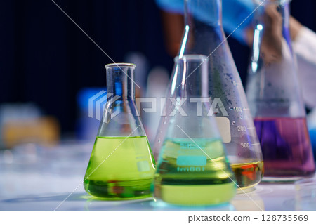 Chemical solutions in glassware during lab experiment Chemical solutions in glassware during lab experiment 128735569