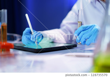 Scientist recording the results of the study in a laboratory journal. Scientist recording the results of the study in a laboratory journal. 128735570