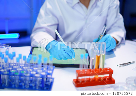 Scientist recording the results of the study in a laboratory journal. 128735572