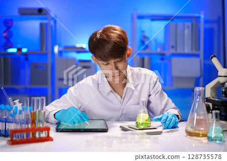 Scientist recording the results of the study in a laboratory journal. 128735578
