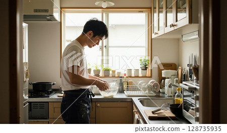一位男廚師在廚房做飯的簡介 128735935