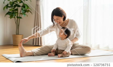 A heartwarming daily life of parents and children enjoying baby yoga 128736731