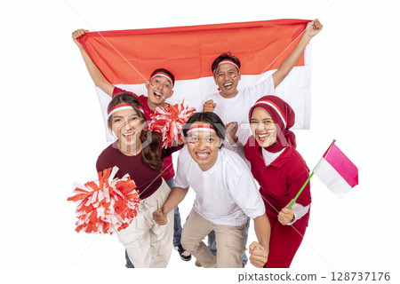 Indonesian southeast asian people celebrating Indonesia Independence Day on the 17th of August by holding the Indonesian national flag isolated over white background. Concept of Kemerdekaan Indonesia Indonesian southeast asian people celebrating Indonesia Independence Day on the 17th of August by holding the Indonesian national flag isolated over white background. Concept of Kemerdekaan Indonesia 128737176