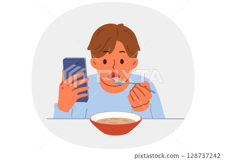 Boy suffering from digital addiction eats and watches video on mobile phone at same time Boy suffering from digital addiction eats and watches video on mobile phone at same time 128737242