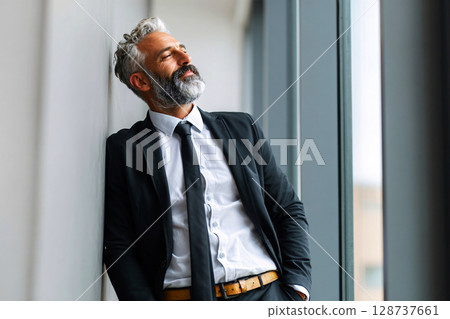 Portrait of mature CEO gazing ahead with motivation and confidence in modern office 128737661